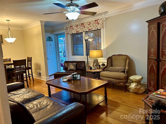 living room with ceiling fan, ornamental molding, light hardwood / wood-style floors, and ornate columns