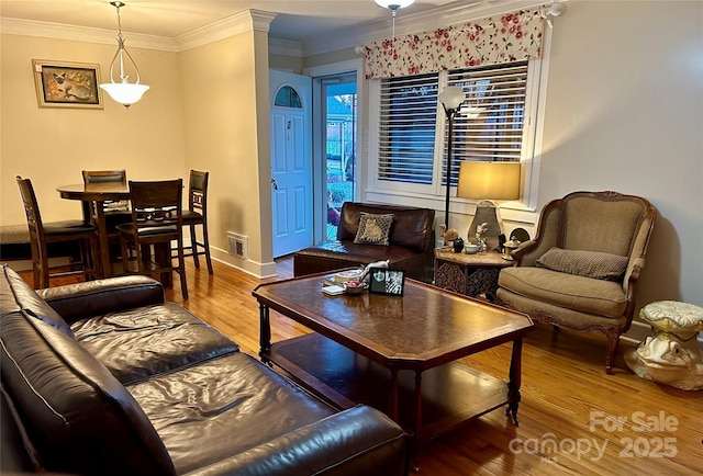 living room featuring wood-type flooring, ornamental molding, and ornate columns