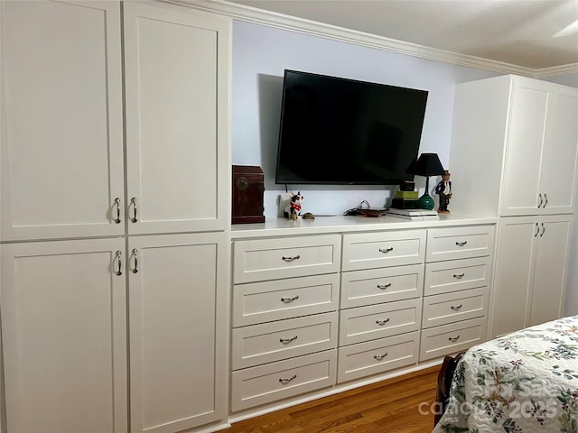 bedroom with ornamental molding and wood-type flooring