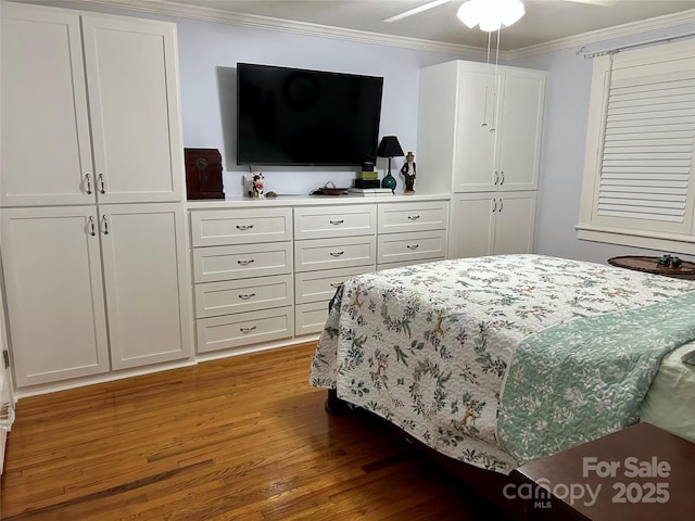 bedroom with crown molding, ceiling fan, and hardwood / wood-style flooring