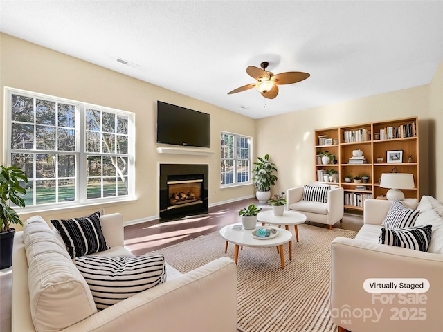 living room featuring ceiling fan and a healthy amount of sunlight