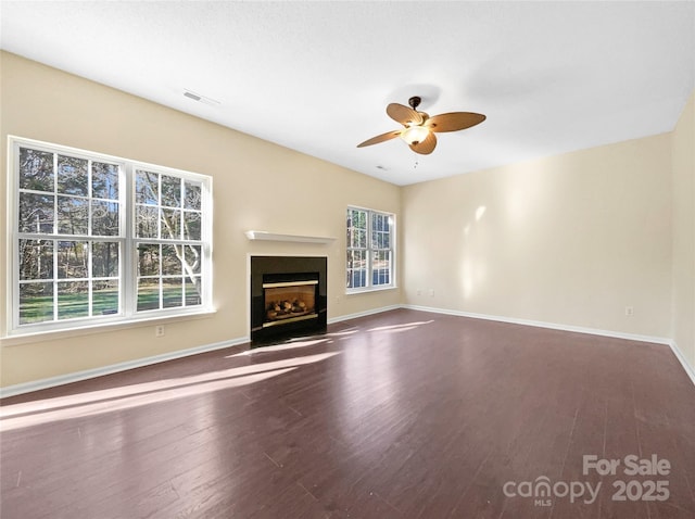 unfurnished living room featuring ceiling fan and dark hardwood / wood-style floors