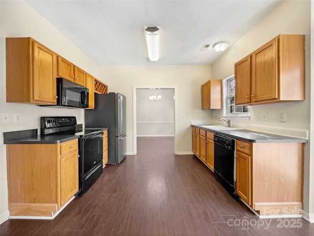 kitchen with black appliances, sink, a textured ceiling, dark hardwood / wood-style flooring, and a chandelier