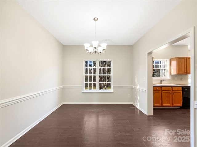 unfurnished dining area featuring a chandelier, dark hardwood / wood-style floors, and sink