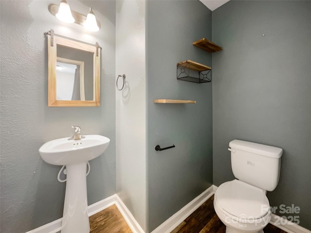 bathroom featuring hardwood / wood-style floors and toilet