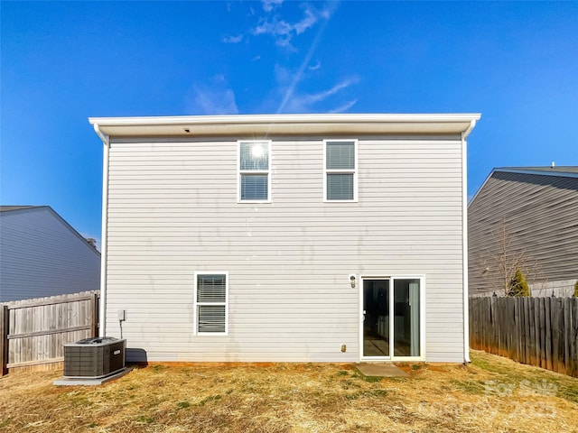 back of house featuring central air condition unit and a yard