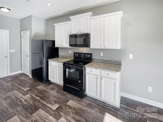 kitchen with light stone countertops, white cabinetry, dark hardwood / wood-style flooring, and black appliances