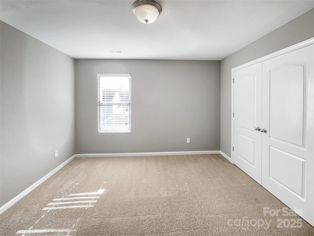 unfurnished bedroom with a closet and carpet flooring