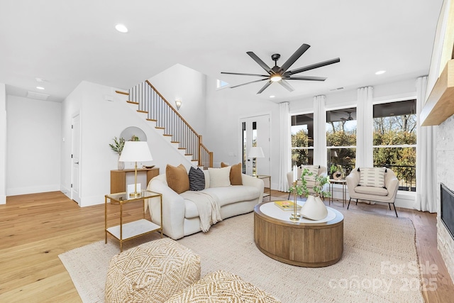 living room with ceiling fan and light hardwood / wood-style flooring