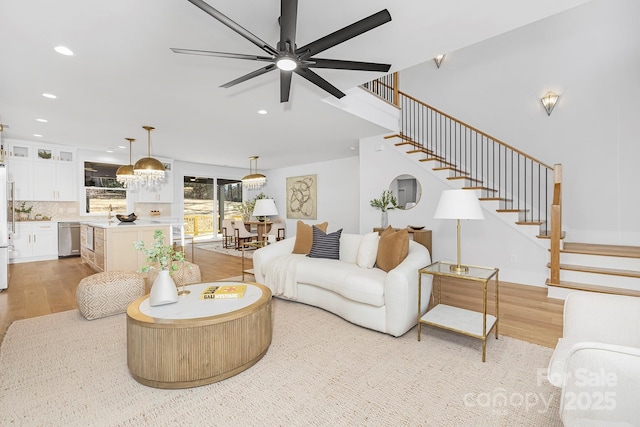 living room featuring ceiling fan and light hardwood / wood-style floors