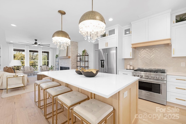 kitchen featuring white cabinets, hanging light fixtures, and premium appliances