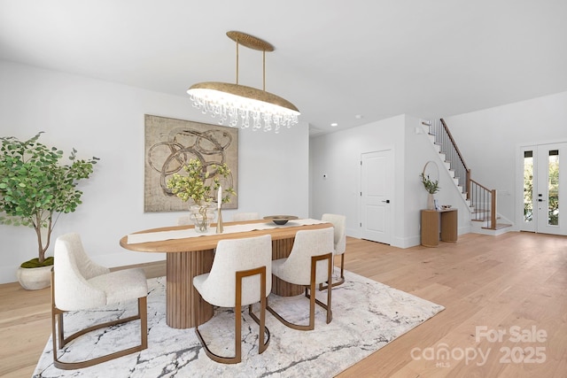 dining area featuring a chandelier, light hardwood / wood-style floors, and french doors