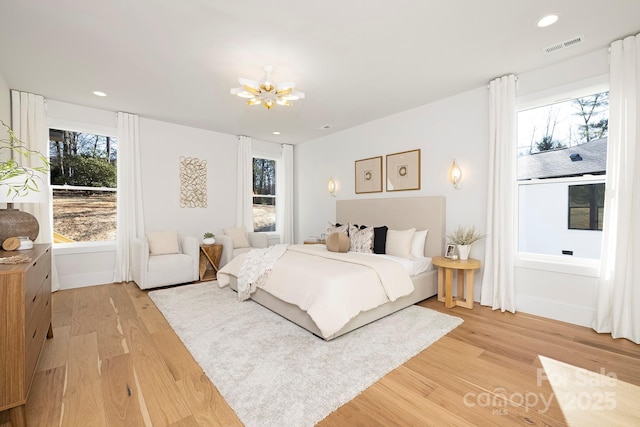 bedroom with hardwood / wood-style flooring and a chandelier