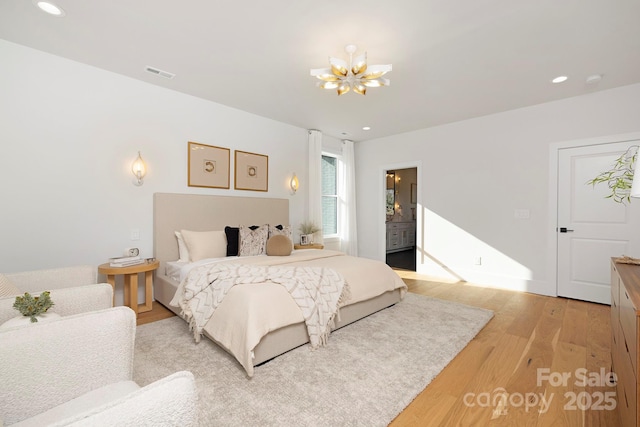 bedroom featuring a notable chandelier and light hardwood / wood-style floors