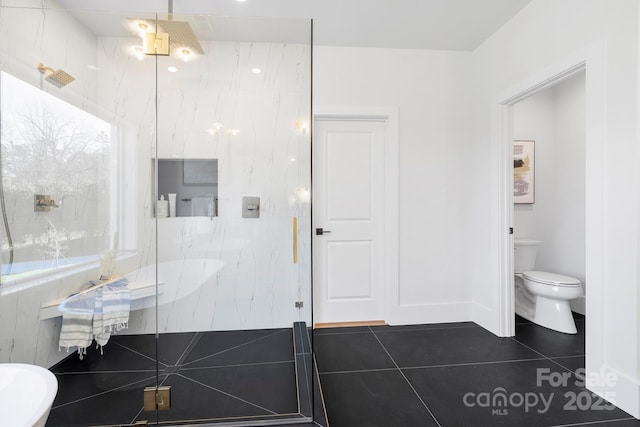 bathroom featuring toilet, tile patterned floors, and a shower with shower door