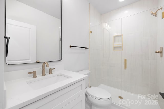 bathroom with vanity, toilet, and a shower with shower door