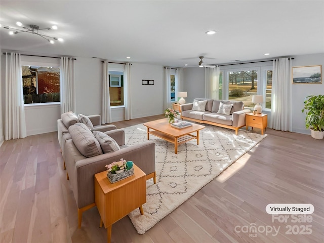 living room with ceiling fan and light hardwood / wood-style flooring