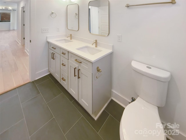 bathroom with toilet, tile patterned flooring, and vanity