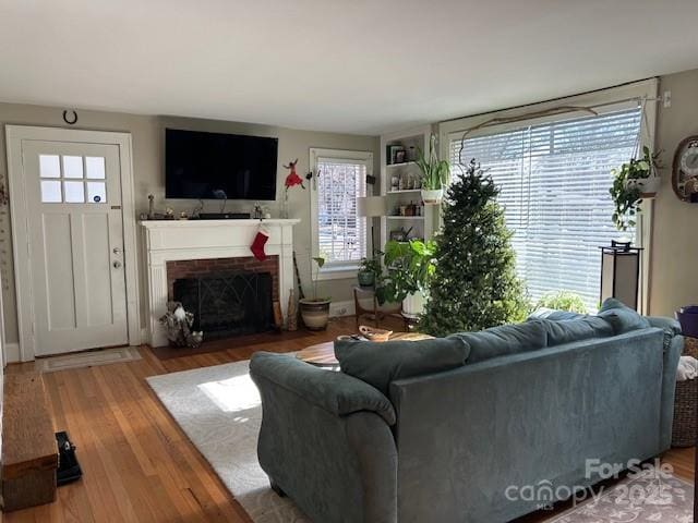 living room with a fireplace, hardwood / wood-style floors, and built in shelves