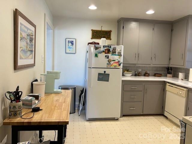 kitchen featuring white appliances, gray cabinetry, and tasteful backsplash