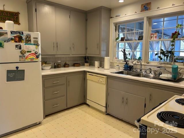 kitchen featuring gray cabinetry, sink, and white appliances