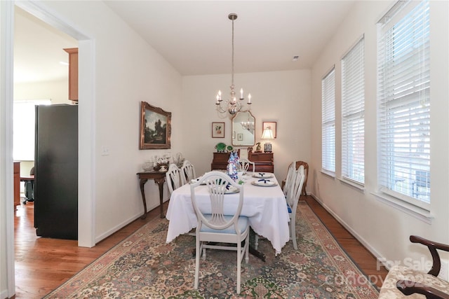 dining room with a notable chandelier and dark hardwood / wood-style floors