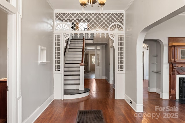 entrance foyer featuring dark wood-type flooring and crown molding