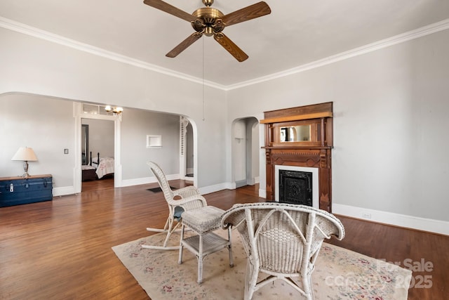 living room with ceiling fan, dark hardwood / wood-style flooring, a high end fireplace, and ornamental molding