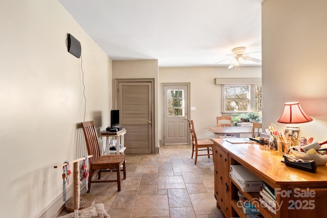 interior space with ceiling fan