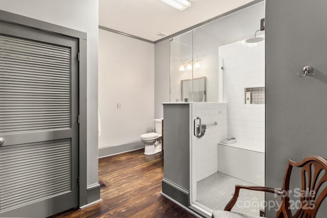 bathroom with toilet, hardwood / wood-style flooring, and a shower with door