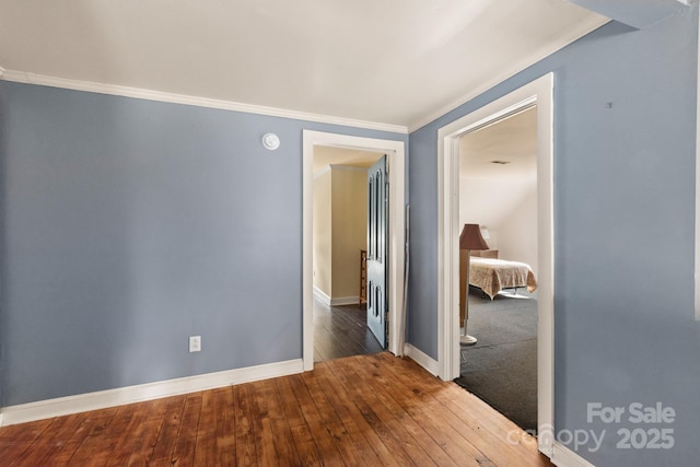 empty room with wood-type flooring and crown molding