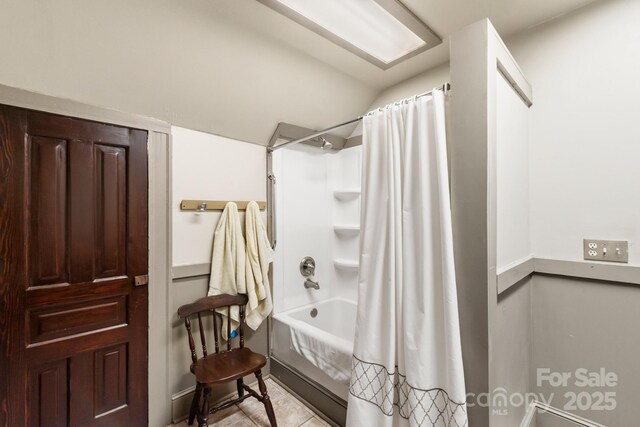 bathroom featuring lofted ceiling, tile patterned flooring, and shower / bathtub combination with curtain