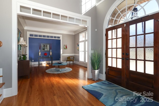 foyer entrance featuring french doors, crown molding, and hardwood / wood-style floors