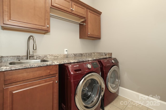 laundry room featuring washing machine and dryer, cabinets, light tile patterned flooring, and sink