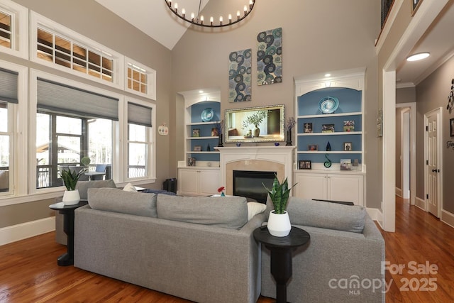 living room featuring hardwood / wood-style floors, built in features, and lofted ceiling