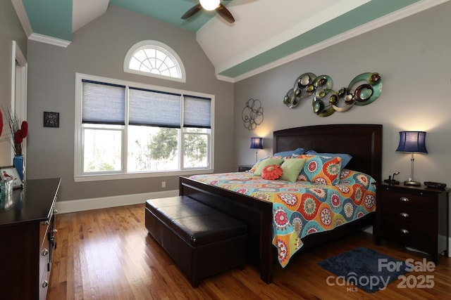 bedroom with vaulted ceiling, ceiling fan, wood-type flooring, and multiple windows