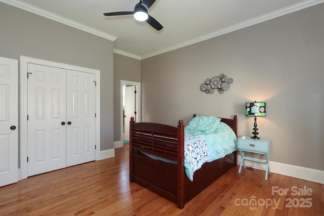 bedroom featuring ceiling fan, hardwood / wood-style floors, a closet, and crown molding