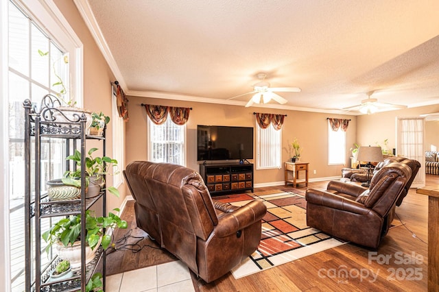 living room featuring ceiling fan, crown molding, a textured ceiling, and light hardwood / wood-style floors