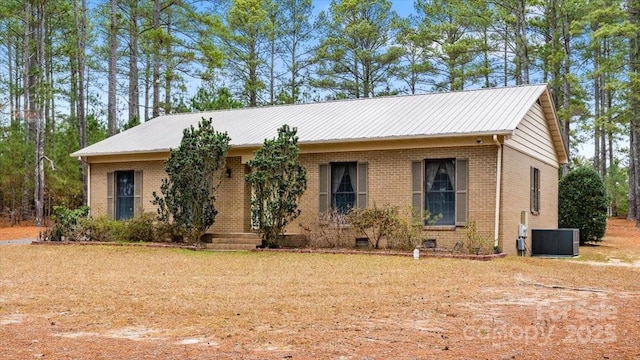 ranch-style home featuring cooling unit and a front yard