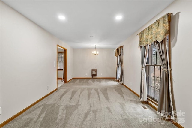 unfurnished room featuring heating unit, light colored carpet, and a notable chandelier