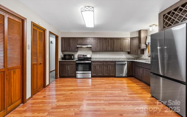 kitchen featuring dark brown cabinets, sink, stainless steel appliances, and light wood-type flooring