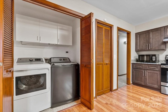 washroom with cabinets, separate washer and dryer, and light hardwood / wood-style flooring