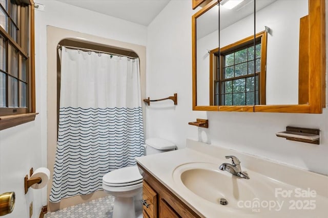 bathroom with toilet, vanity, and a shower with shower curtain