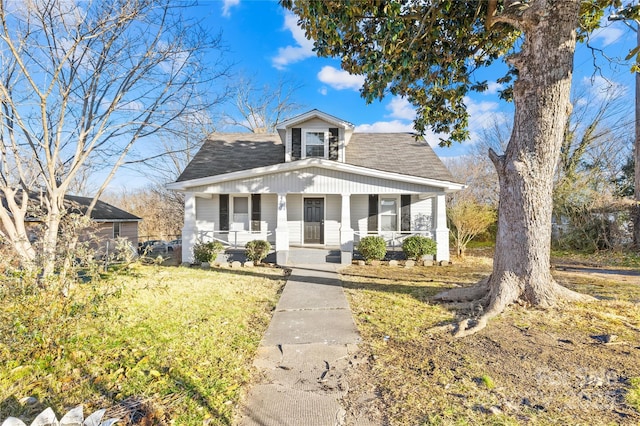 bungalow-style home with covered porch and a front yard