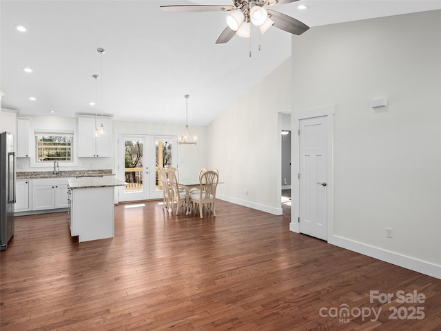 kitchen featuring white cabinetry, french doors, stainless steel refrigerator, pendant lighting, and a center island