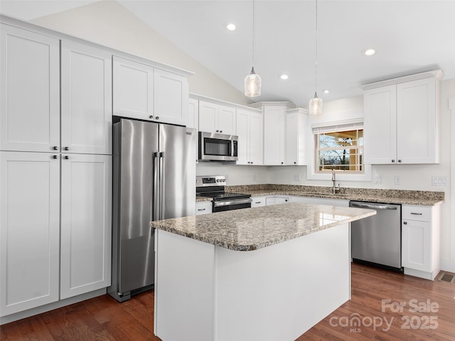 kitchen featuring appliances with stainless steel finishes, sink, white cabinetry, and a center island