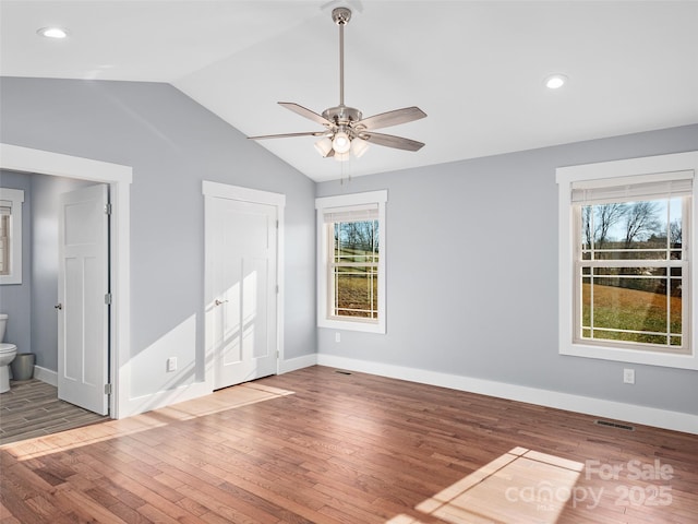 unfurnished room featuring lofted ceiling, wood-type flooring, and ceiling fan