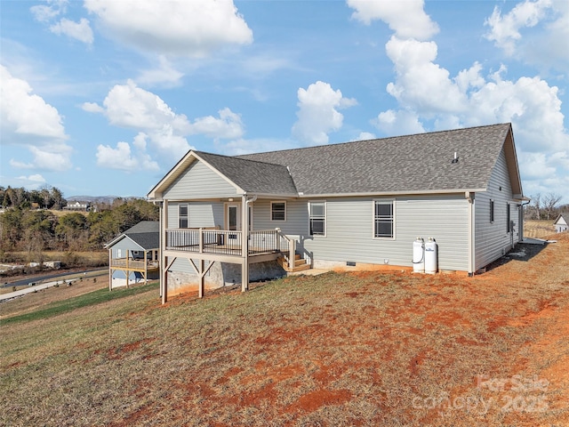 rear view of property featuring a wooden deck and a lawn