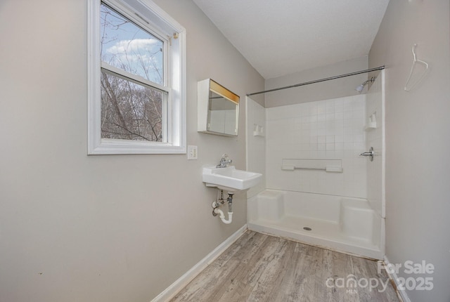 bathroom with sink, hardwood / wood-style floors, a textured ceiling, and walk in shower