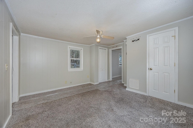 unfurnished bedroom with a textured ceiling, ornamental molding, ceiling fan, and carpet